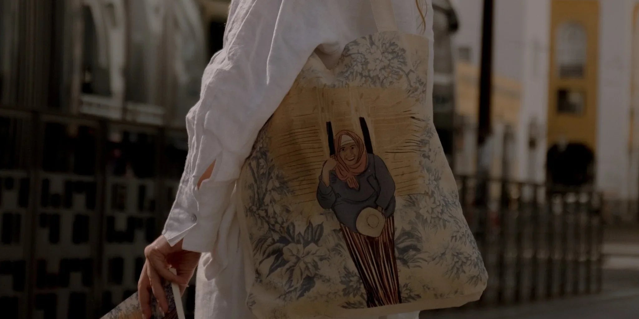 Woman in white outfit carrying ethnik illustrated Moroccan tote bag and pouch outdoors