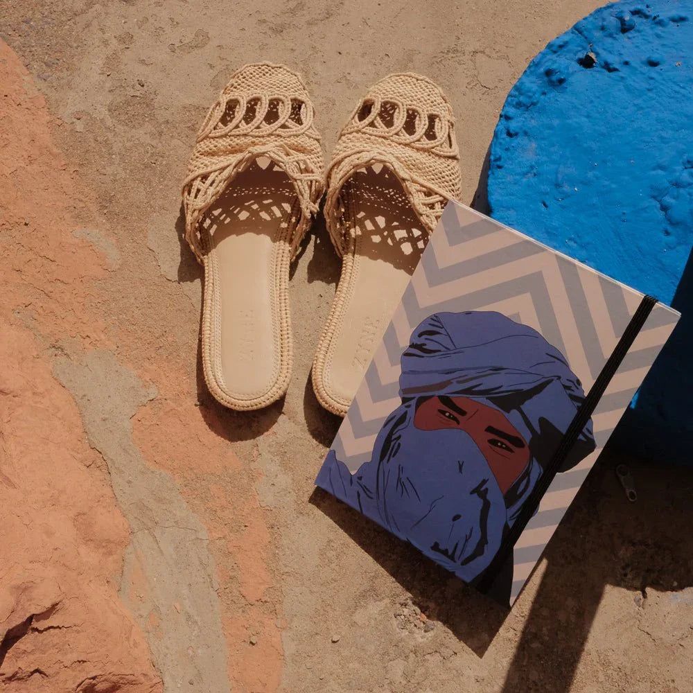 Ethnik Moroccan woven sandals and illustrated notebook with blue turban design on rustic stone