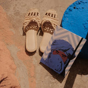 Ethnik Moroccan woven sandals and illustrated notebook with blue turban design on rustic stone