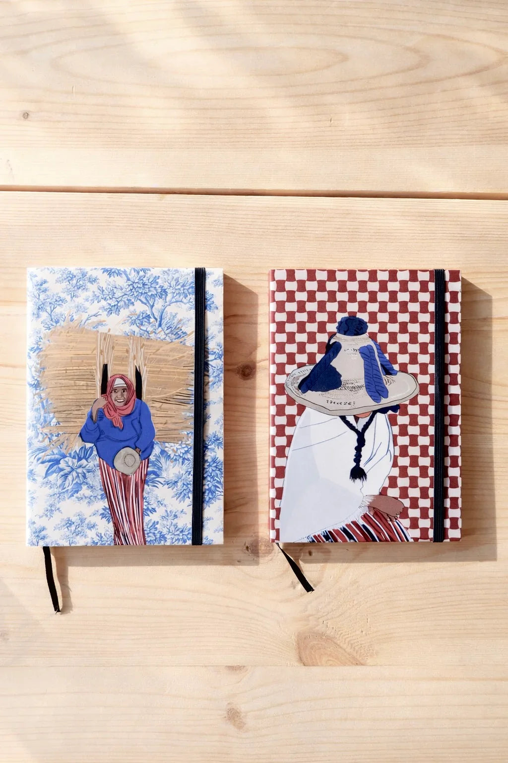Two ethnik Moroccan notebooks with original illustrated covers on a wooden surface