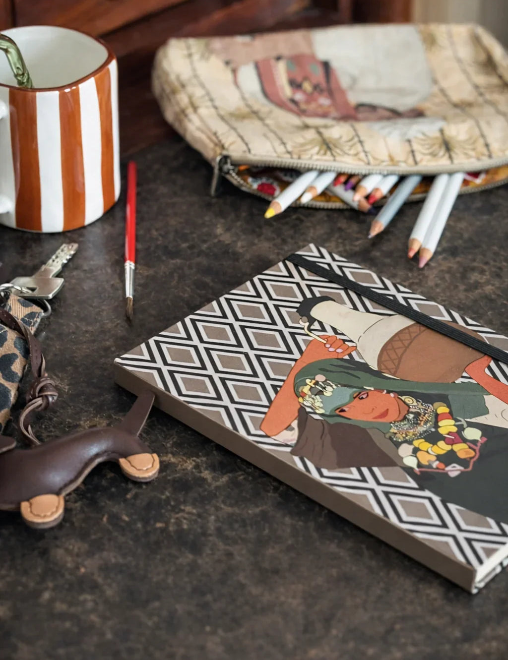 Ethnik Moroccan stationery set with illustrated notebook, striped mug, pouch, and colored pencils on table