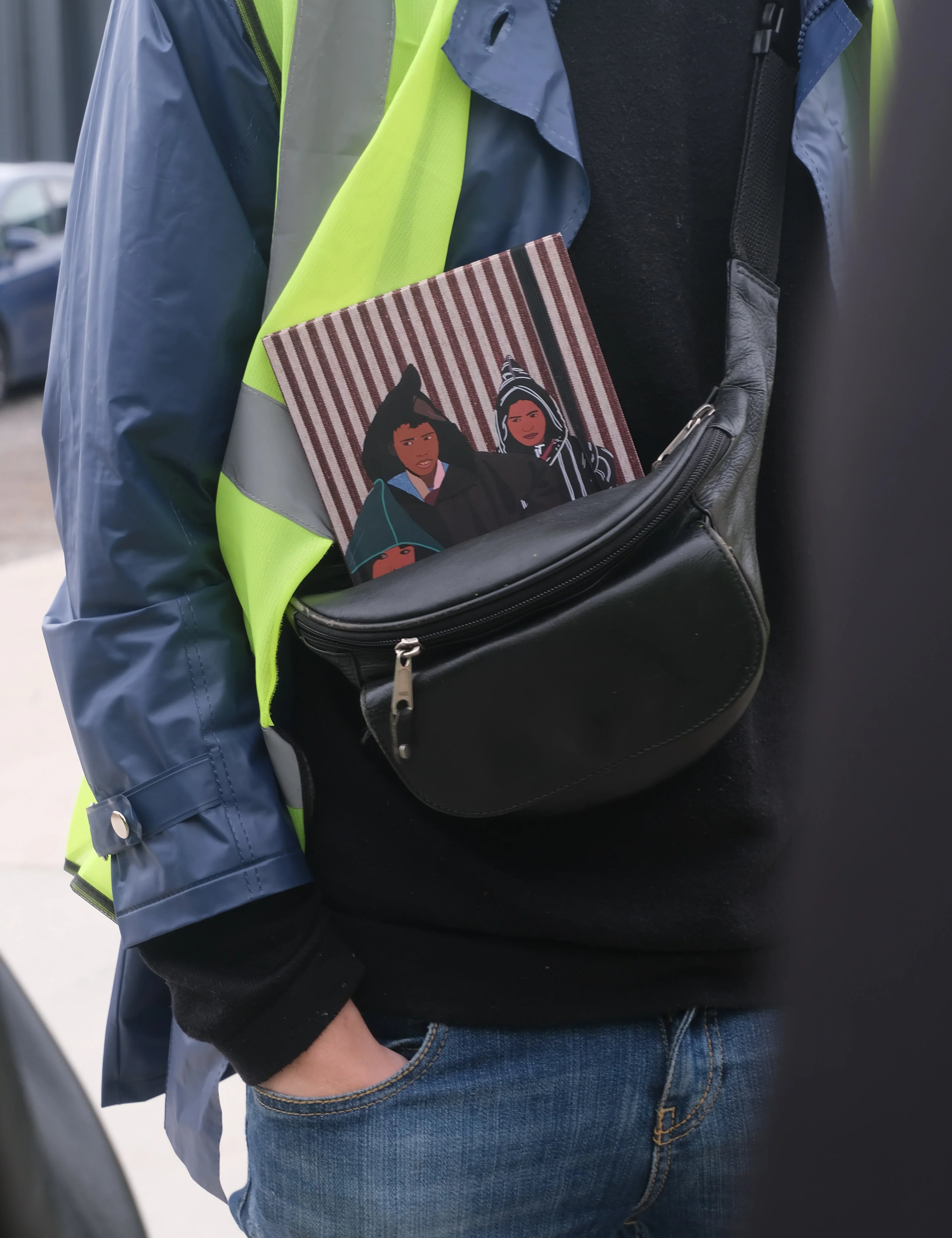 ethnik Moroccan illustrated notebook in black bag, person wearing blue jacket and yellow vest
