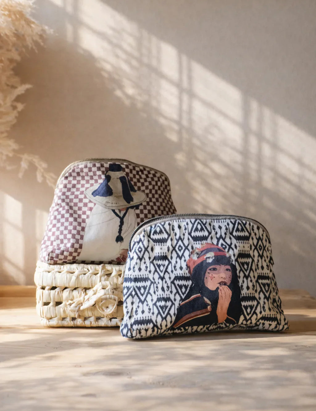 ethnik Moroccan pouch bags with illustrated designs on woven basket, sunlight background