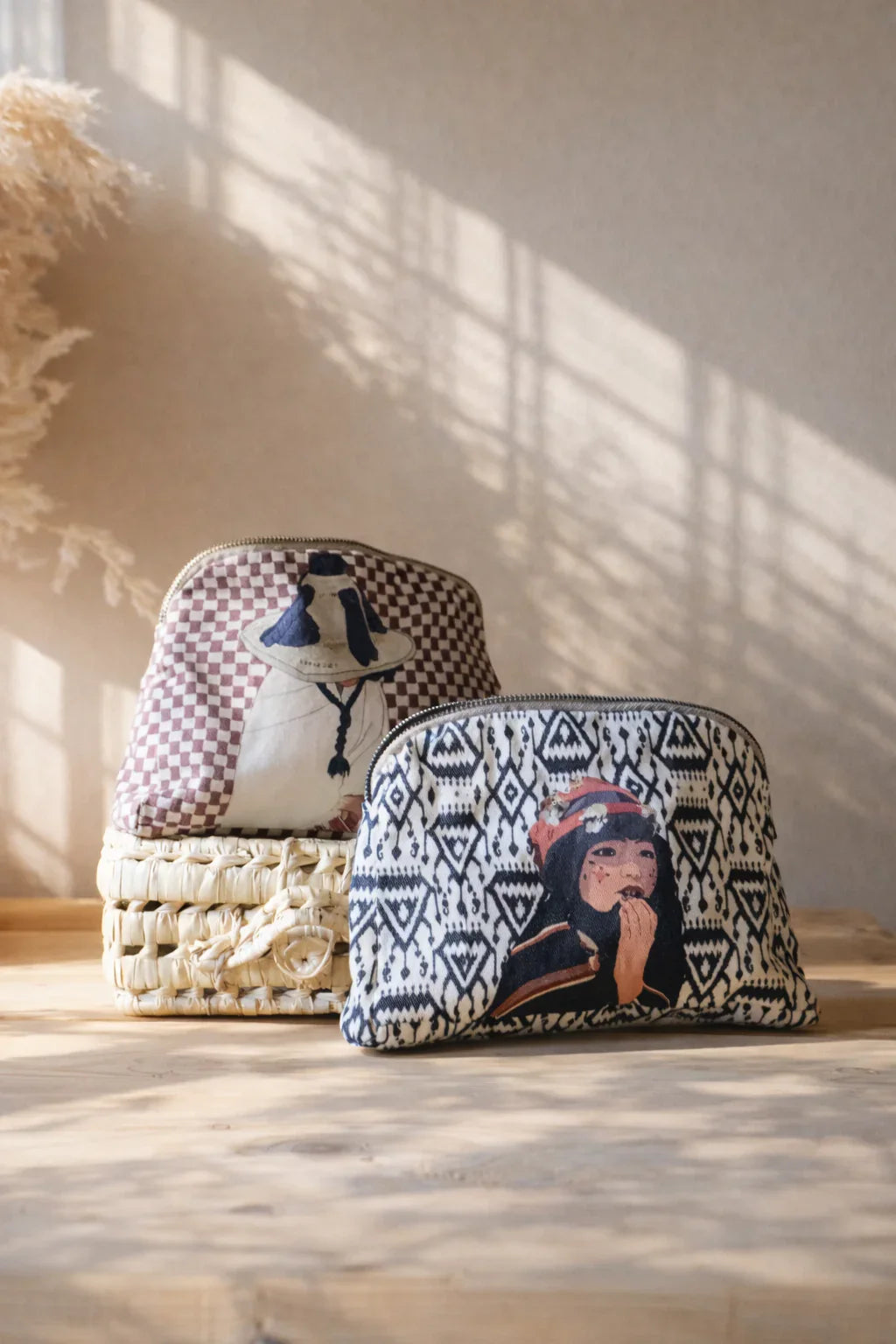 ethnik Moroccan pouch bags with illustrated designs on woven basket, sunlight background