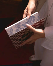 Hand holding ethnik patterned notebooks with Moroccan illustrations and checkered design