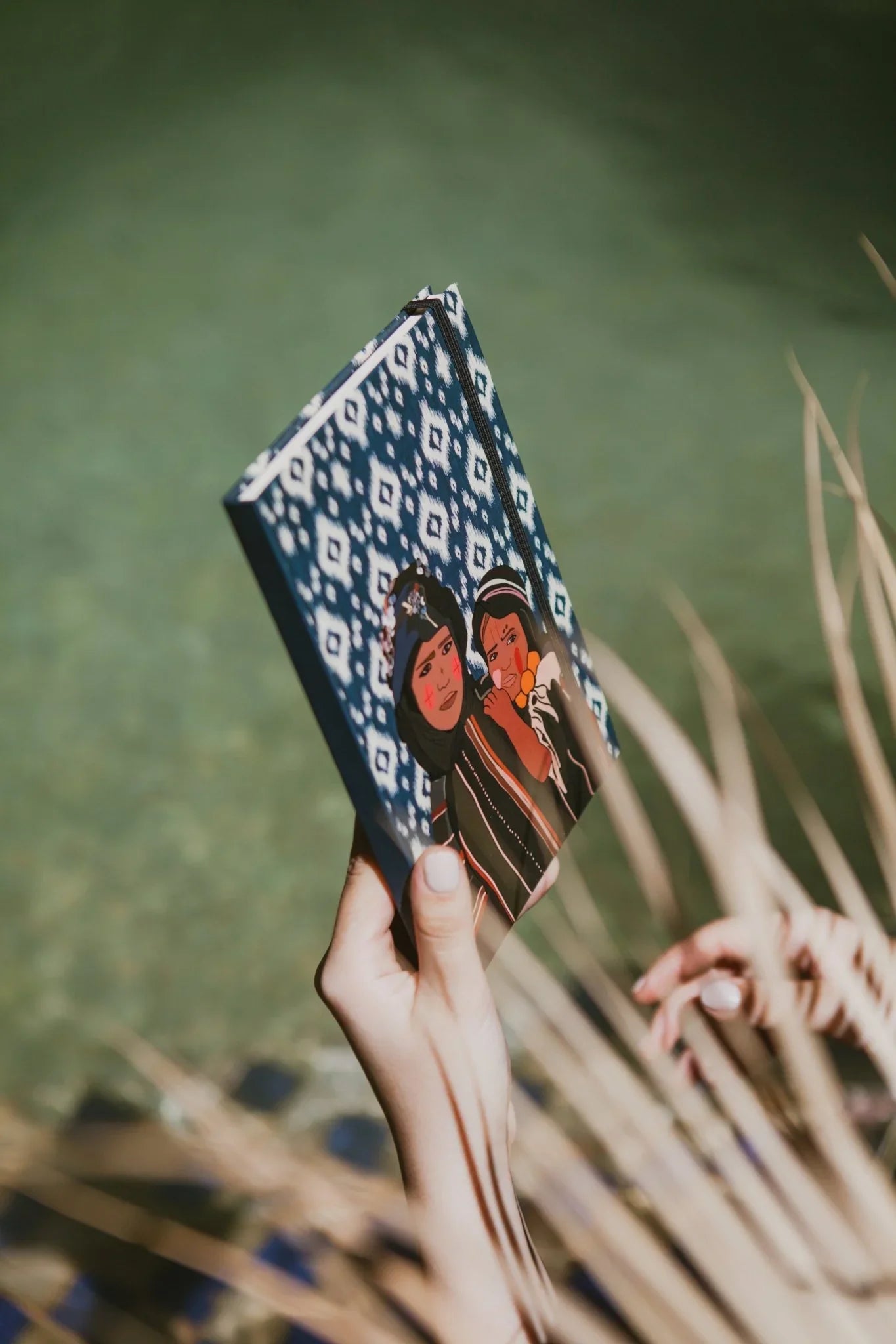 Hand holding ethnik Moroccan stationery notebook with blue geometric pattern and illustrated cover