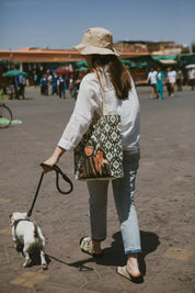 Woman walking dog in Moroccan square, carrying ethnik illustrated tote bag
