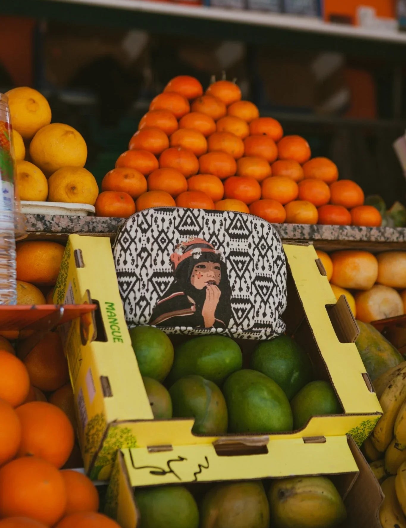 Ethnik Moroccan illustrated pouch on fruit market stand with oranges and mangoes