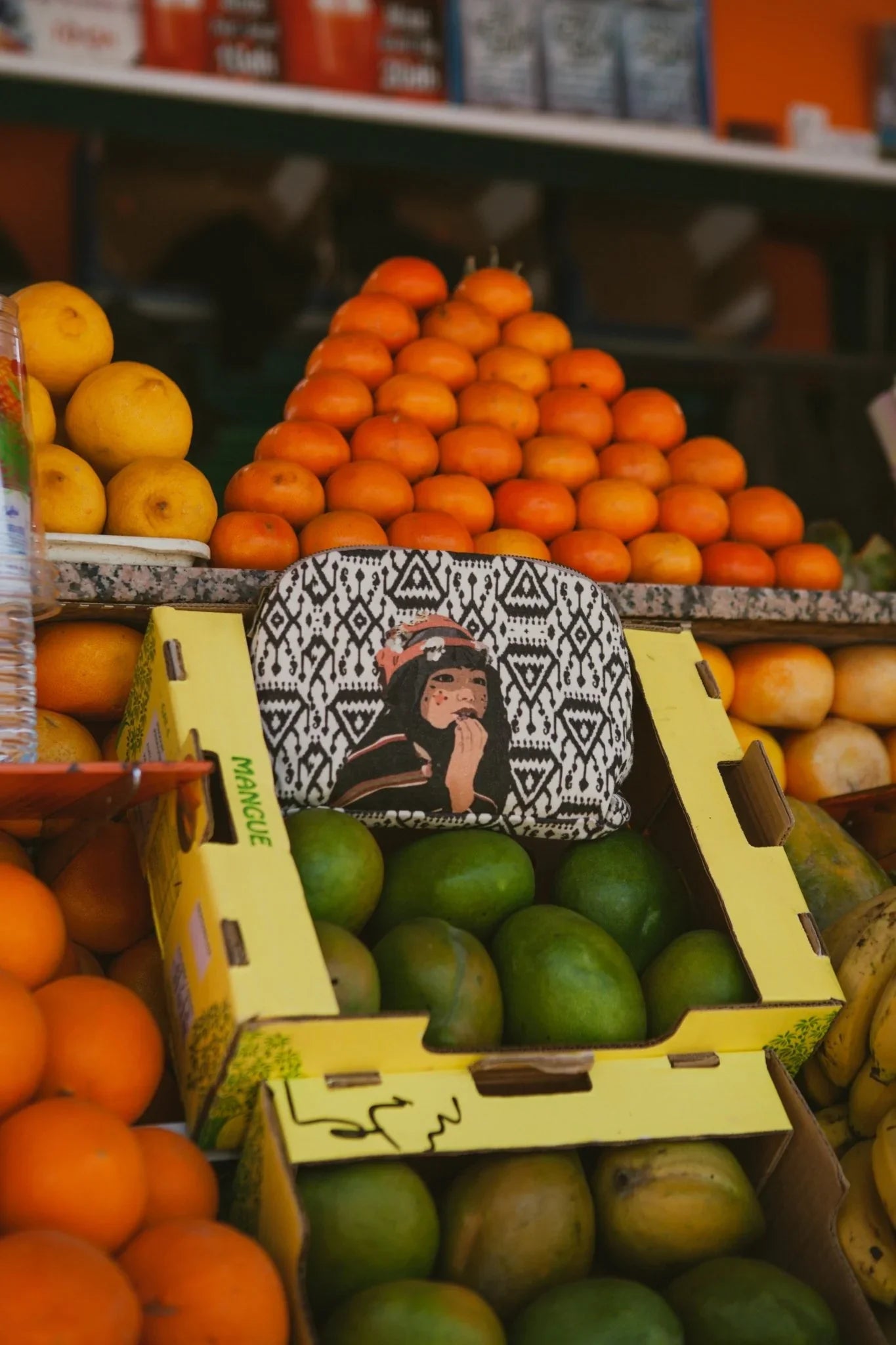 Ethnik Moroccan illustrated pouch on fruit market stand with oranges and mangoes
