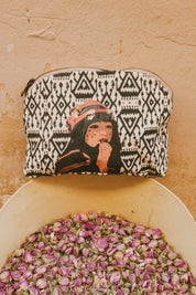 Ethnik Morocco pouch with illustrated girl, geometric pattern, above dried rose buds.