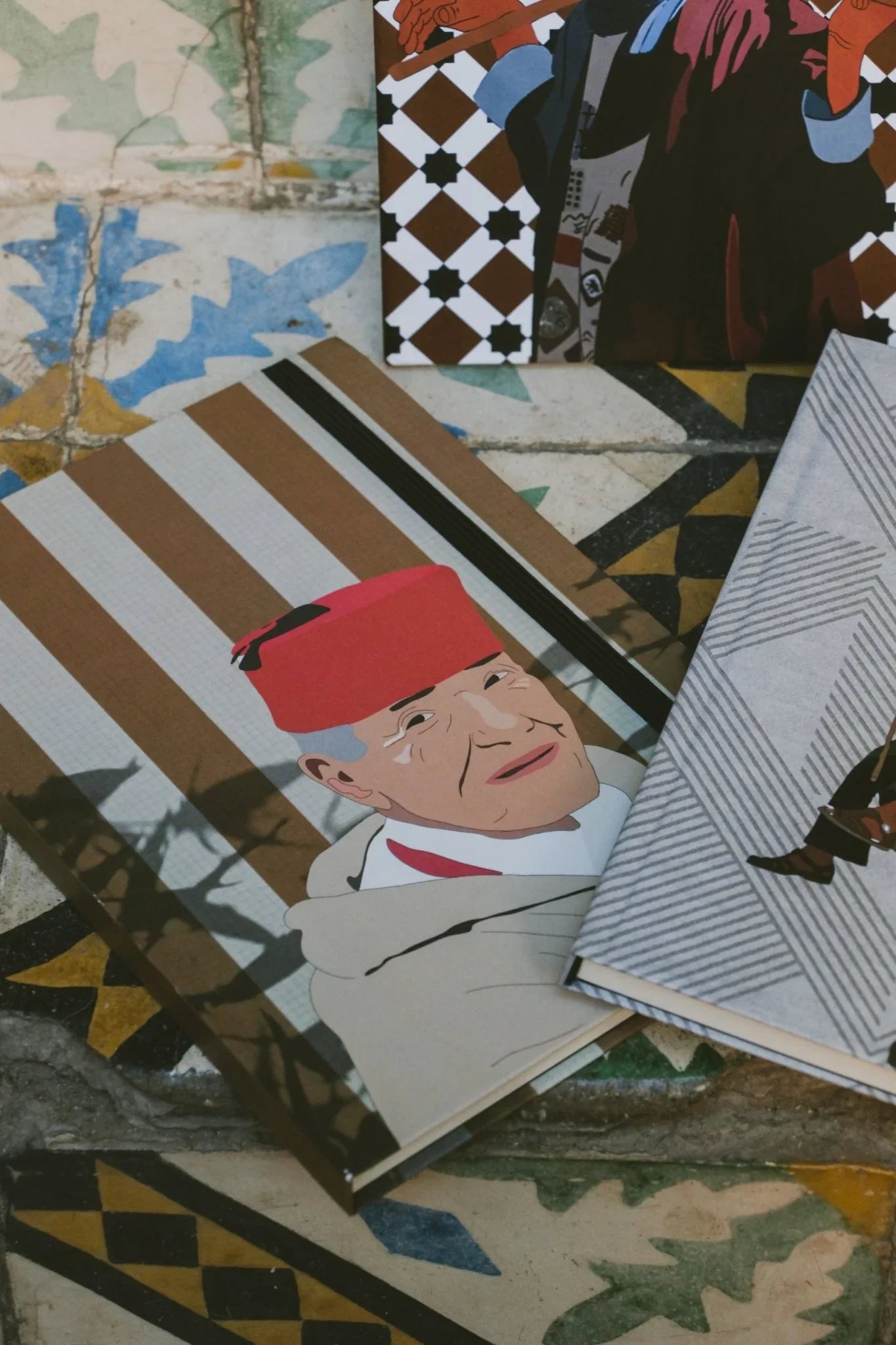 Moroccan illustrated notebooks from ethnik on patterned ceramic tiles, featuring traditional designs.