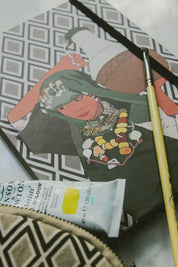 Ethnik stationery notebook with Moroccan illustration, paintbrush, and paint tube on table