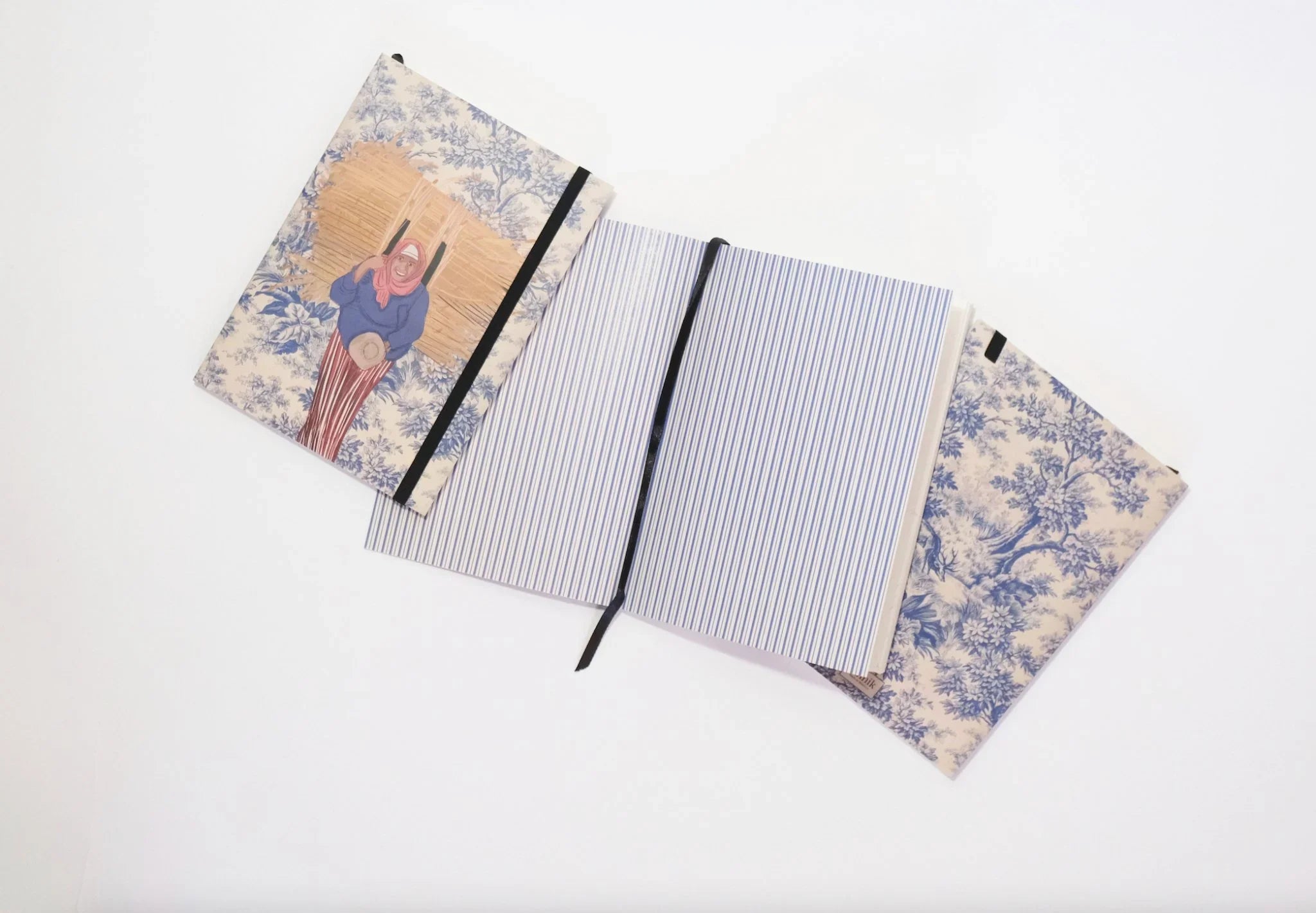 ethnik Moroccan illustrated notebooks with blue floral covers and one open to striped pages