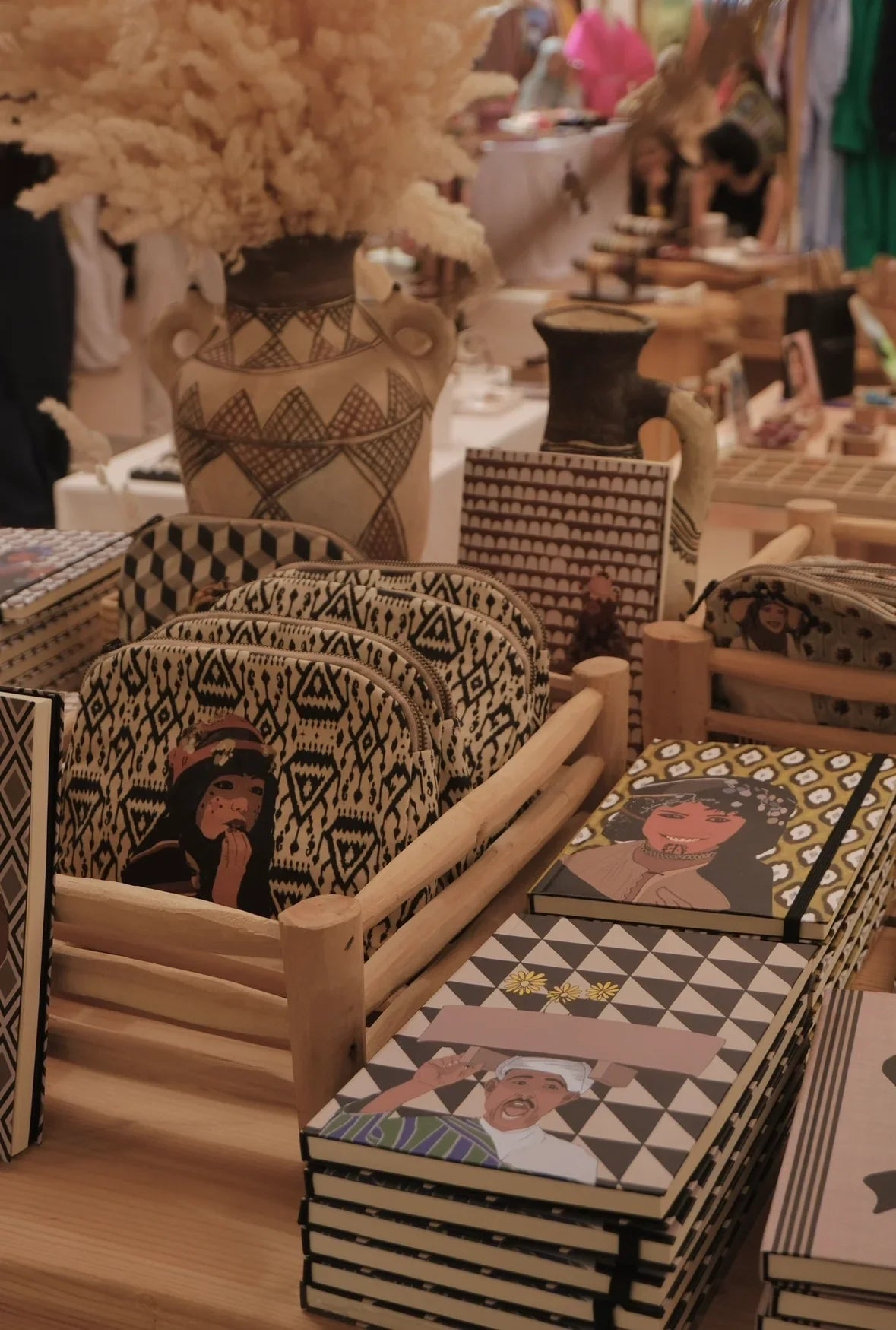 Ethnik Moroccan artisan notebooks and pouches with geometric patterns and original illustrations on a wooden table.