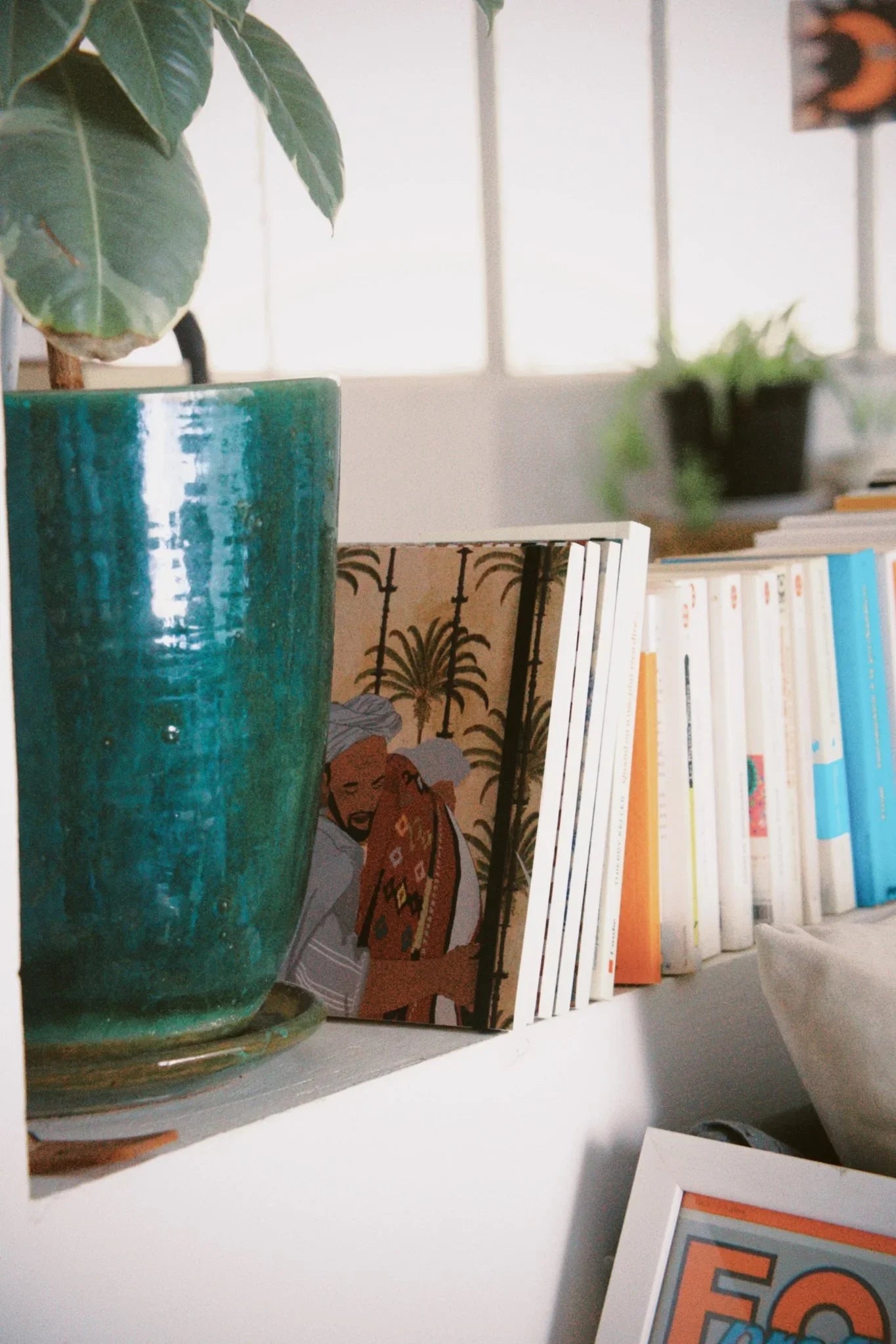 Ethnik stationery on shelf with Moroccan illustration, books, and green ceramic plant pot.